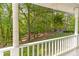 View from the front porch with a hanging fern overlooking the lush yard with mature trees at 1981 Luke Edwards Rd, Dacula, GA 30019
