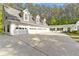 Spacious four car garage with an expansive driveway, garden, and well-maintained landscaping at 1981 Luke Edwards Rd, Dacula, GA 30019