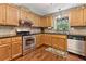 Modern kitchen features stainless steel appliances, wood cabinets and ample counter space at 1981 Luke Edwards Rd, Dacula, GA 30019