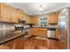 Updated kitchen features wood cabinets, stone backsplash, and stainless-steel appliances at 1981 Luke Edwards Rd, Dacula, GA 30019