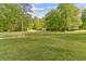 View of the property featuring a grassy field, mature trees, and a shed in the distance at 1981 Luke Edwards Rd, Dacula, GA 30019