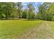 Wide open, grassy area with mature trees, providing a sense of tranquility and natural beauty at 1981 Luke Edwards Rd, Dacula, GA 30019