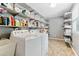 Laundry room boasts ample shelving, storage, washer and dryer, and easy access sink at 1981 Luke Edwards Rd, Dacula, GA 30019
