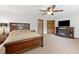 Main bedroom with fireplace and TV; features a ceiling fan and neutral carpeting at 1981 Luke Edwards Rd, Dacula, GA 30019