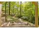 Outdoor swing in a wooded area with views of the serene creek, creating a peaceful retreat at 1981 Luke Edwards Rd, Dacula, GA 30019