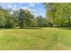 Lush green yard surrounded by mature trees, showcasing outdoor space at 1981 Luke Edwards Rd, Dacula, GA 30019