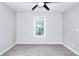 Cozy bedroom featuring neutral paint, plush carpet, a window, and modern ceiling fan at 931 Bonaventure Way, Lawrenceville, GA 30044