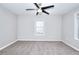 Bright bedroom with carpet, ceiling fan, neutral paint, and a window providing natural light at 931 Bonaventure Way, Lawrenceville, GA 30044