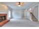 Open living space featuring a brick fireplace, neutral carpet, and staircase at 931 Bonaventure Way, Lawrenceville, GA 30044