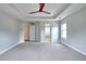 Spacious main bedroom featuring a tray ceiling, ceiling fan, neutral paint, and carpeted floors at 931 Bonaventure Way, Lawrenceville, GA 30044