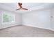 Spacious main bedroom with tray ceilings, ceiling fan, large window, and comfortable carpeting at 931 Bonaventure Way, Lawrenceville, GA 30044