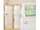 Modern bathroom featuring a shower with a gold frame and a window providing natural light at 931 Bonaventure Way, Lawrenceville, GA 30044