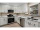 Bright kitchen featuring stainless steel appliances, white cabinetry, and ample counter space at 136 Peachtree Memorial Nw Dr # Va2, Atlanta, GA 30309