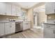 Well-lit kitchen featuring white cabinets, stainless steel appliances, wood-look flooring, and open layout at 136 Peachtree Memorial Nw Dr # Va2, Atlanta, GA 30309