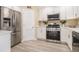 Modern kitchen with stainless steel appliances, white cabinets, quartz countertops, and wood-look floors at 136 Peachtree Memorial Nw Dr # Va2, Atlanta, GA 30309