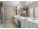 Bright bathroom featuring a double vanity with white countertops, large mirror, and a glass-enclosed shower at 226 Hames Rd # 335, Woodstock, GA 30188
