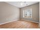 This bedroom features hardwood floors, neutral paint, a ceiling fan, and a window that provides natural light at 226 Hames Rd # 335, Woodstock, GA 30188