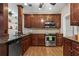 Well-equipped kitchen featuring stainless steel appliances, hardwood floors, and cherry cabinets and granite counters at 226 Hames Rd # 335, Woodstock, GA 30188