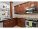 A modern kitchen with stainless steel appliances, including a microwave, oven, and wooden cabinets at 226 Hames Rd # 335, Woodstock, GA 30188