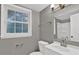 Bathroom featuring a toilet, window, mirror, sink and storage at 2417 Jade Dr, Lawrenceville, GA 30044