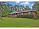 Charming one-story brick home featuring a lush green lawn and mature trees in a serene neighborhood setting at 2417 Jade Dr, Lawrenceville, GA 30044