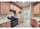 Modern kitchen featuring stainless steel oven and cooktop, wooden cabinets, and luxury vinyl plank flooring at 3733 Sidney Lanier Blvd, Duluth, GA 30096