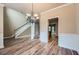 Bright living room featuring luxury vinyl plank flooring, a modern chandelier, and a staircase to the second floor at 3733 Sidney Lanier Blvd, Duluth, GA 30096