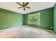 Primary bedroom with a tray ceiling, ceiling fan, carpet flooring, and a large window providing ample natural light at 3733 Sidney Lanier Blvd, Duluth, GA 30096