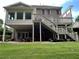 Beautiful backyard view of two-story brick home with large deck, stairs, and green lawn at 608 Tabbystone Nw St, Marietta, GA 30064