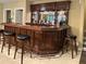 Home bar area with dark wood cabinetry, mirrors, a sink, and black leather bar stools at 608 Tabbystone Nw St, Marietta, GA 30064
