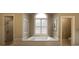 Bathroom featuring a soaking tub under a window and glass enclosed shower at 608 Tabbystone Nw St, Marietta, GA 30064