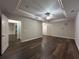 Spacious bedroom featuring a tray ceiling, hardwood floors and three doors at 608 Tabbystone Nw St, Marietta, GA 30064
