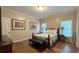 Bedroom featuring hardwood floors, two windows, and two bedside lamps at 608 Tabbystone Nw St, Marietta, GA 30064