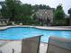 Community pool with lounge chairs and a view of a home surrounded by trees at 608 Tabbystone Nw St, Marietta, GA 30064