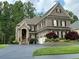Beautiful brick home with a well-manicured lawn, lush trees, and an expansive driveway at 608 Tabbystone Nw St, Marietta, GA 30064