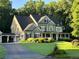 Stately grey home with a large front porch, attached garage, and expansive lawn with a circular driveway at 608 Tabbystone Nw St, Marietta, GA 30064