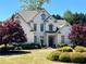 Beautiful white home with manicured front lawn and mature landscaping featuring vibrant red trees at 608 Tabbystone Nw St, Marietta, GA 30064
