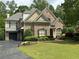 Charming brick home with well-manicured lawn, lush landscaping, and a paved driveway at 608 Tabbystone Nw St, Marietta, GA 30064