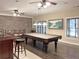 Game room with a pool table, bar, exposed brick wall, and dark hardwood floors at 608 Tabbystone Nw St, Marietta, GA 30064