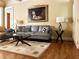 Inviting living room featuring a stylish gray sofa, elegant glass coffee table, and beautiful hardwood floors at 608 Tabbystone Nw St, Marietta, GA 30064