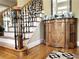 Elegant staircase with black iron railing, hardwood floors, and a decorative cabinet at 608 Tabbystone Nw St, Marietta, GA 30064