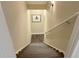 Staircase with neutral walls, newel post, and capped wall mounted handrail at 608 Tabbystone Nw St, Marietta, GA 30064
