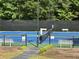 A well-maintained blue and green tennis court with benches and net in a beautiful landscaped community at 608 Tabbystone Nw St, Marietta, GA 30064