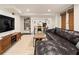 Finished basement with a large leather sofa, custom shelving, and an adjacent work area at 615 Wilson Nw Rd, Atlanta, GA 30318
