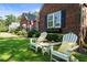 Relaxing Adirondack chairs sit on a lush lawn in front of a classic brick home with manicured landscaping at 615 Wilson Nw Rd, Atlanta, GA 30318