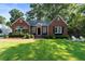 Charming brick home featuring a beautifully landscaped front yard with inviting Adirondack chairs and lush green grass at 615 Wilson Nw Rd, Atlanta, GA 30318