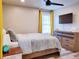 Comfortable bedroom with a ceiling fan, large windows with lace curtains, and wooden dresser at 1452 Mercer Ave, Atlanta, GA 30337