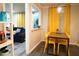 Dining area with yellow chairs and table next to living room area with blue sofa and view to front door at 1452 Mercer Ave, Atlanta, GA 30337
