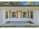 A covered front entry featuring white walls, wood shutters, and a welcome mat at 1452 Mercer Ave, Atlanta, GA 30337