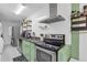 Modern kitchen with stainless steel appliances, green cabinets, and sleek countertops at 1452 Mercer Ave, Atlanta, GA 30337